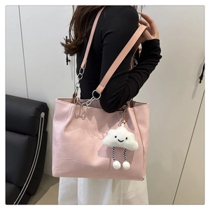 Pink faux leather tote bag detail with geometric stitching and cloud plush charm decoration