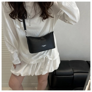 Close-up of black PU leather bucket bag with white fashion text and silver buckle