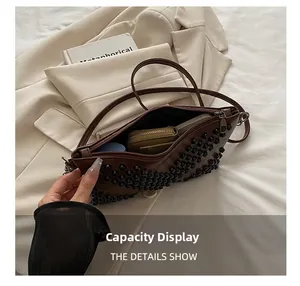 Detail showing high capacity interior of a dark brown studded envelope handbag with daily items