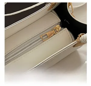 Detail of the white stone pattern handbag showing the metal zipper and woven handle