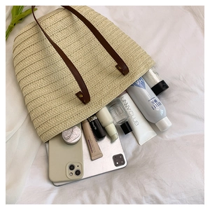 Spacious woven tote bag with brown leather straps showing interior capacity for tablets