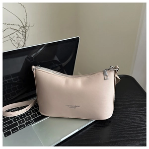 Close-up of beige leather bucket bag featuring fashion text and adjustable strap