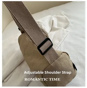 Detail of adjustable wide woven shoulder strap on khaki nylon crossbody chest bag