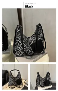 Close-up of black tote bag with white floral embroidery and leather patch detail