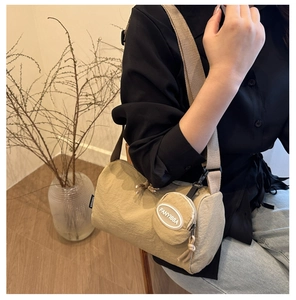 Detail of khaki nylon cylinder crossbody bag with matching round coin purse and strap