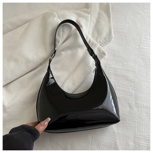 Gros plan du sac baguette en cuir verni noir avec une finition miroir brillante