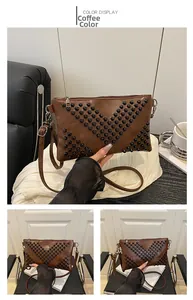 Detail of coffee brown envelope clutch bag featuring black rivets and slim shoulder strap