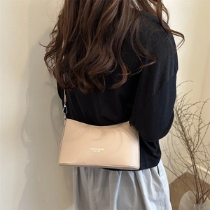 Chic beige bucket shoulder bag in PU leather shown on model in a minimalist setting