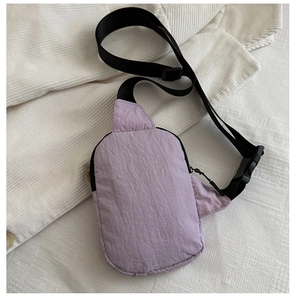 Dettaglio della borsa a tracolla in nylon viola chiaro con tracolla nera regolabile e tessuto