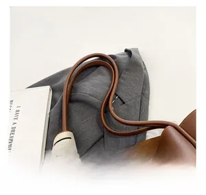 Detail of brown leather tote bag straps with a decorative black and white silk scarf