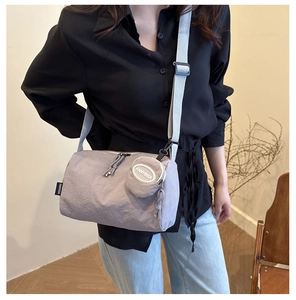 Detail view of grey nylon shoulder bag with matching round coin pouch on strap
