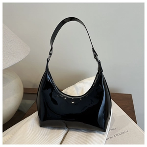Détail du sac croissant en cuir verni noir brillant avec fermeture éclair argentée