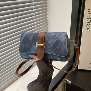 Sac baguette en denim bleu avec bandoulière en cuir marron et boucle dorée en forme de H