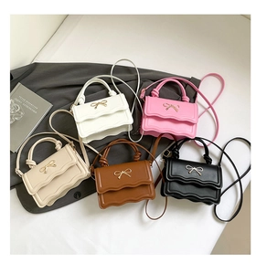 Detailed close-up showing five color variants with elegant metal bow and wavy flap design