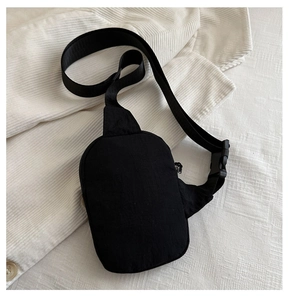 Dettaglio del borsello nero in nylon con tracolla intrecciata e fibbia a scatto