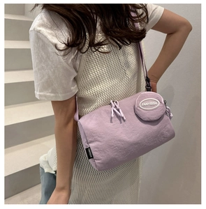 Close-up of a purple nylon crossbody bag with matching round coin pouch and dual zippers