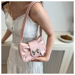 Detailed shot of pink pleated underarm bag featuring a metallic silver bow buckle clasp