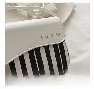 Détail du sac bandoulière blanc en PU avec motif touches de piano et imprimé I LIKE MUSIC