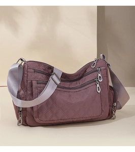 Detailed quilted crossbody bag with multi-zipper pockets and wide fabric strap