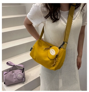Detail of ginger yellow nylon crossbody bag with adjustable wide strap and round coin pouch