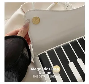 Détail du fermoir magnétique sur sac en PU blanc avec motif de touches de piano