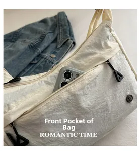 Dettaglio della tasca frontale con cerniera della borsa in nylon beige con vano cellulare