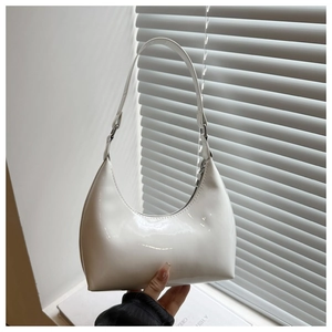 Gros plan d'un sac hobo en cuir verni blanc avec une finition brillante et un design épuré