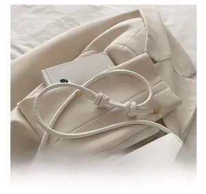 Détail du sac à bandoulière en PU blanc avec sangle nouée et motif touches de piano