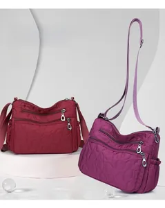 Detail of burgundy and purple nylon crossbody bags with heart-shaped quilted textures