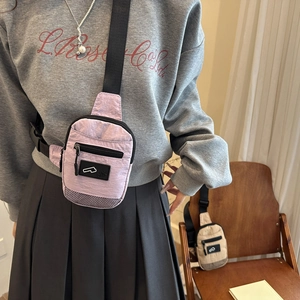 Borsa a tracolla in nylon rosa e beige con dettaglio in rete indossata da una modella