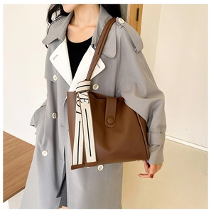 Brown leather tote bag featuring a wide webbed strap with white LOVE lettering detail