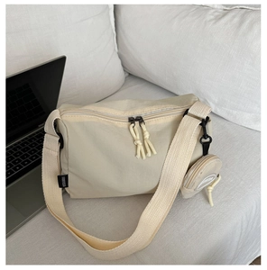 Detail of cream nylon crossbody bag with detachable round coin purse and wide strap