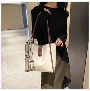 Detail of off-white tote bag with brown straps and a decorative LOVE printed silk scarf