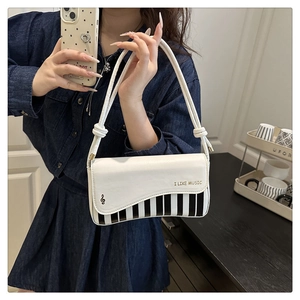Détail du sac bandoulière en PU blanc avec motif touches de piano et imprimé musical