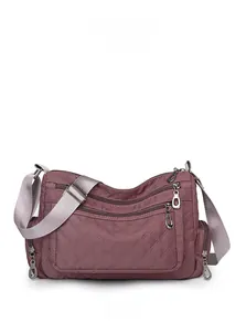 Front view detail of quilted nylon crossbody bag featuring multiple zipper compartments