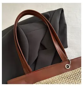 Detail of woven tote bag with premium brown leather handle and silver metal ring buckle