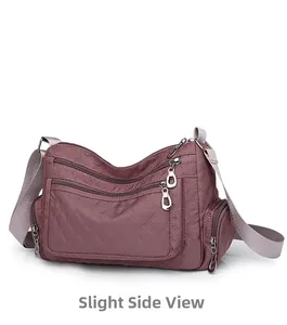 Side view of mauve quilted nylon crossbody bag with multi-layer zippers and wide strap