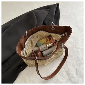 Detail view of woven straw tote bag capacity with cosmetics and sunglasses inside