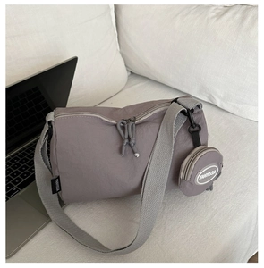 Detail view of purple nylon shoulder bag with adjustable strap and round mini coin purse