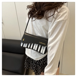 Détail du sac à bandoulière créatif en forme de piano avec imprimé musical et notes en PU