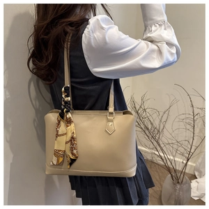 Detail of beige tote bag with slim shoulder strap and elegant vintage printed silk scarf