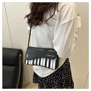 Détail du sac à bandoulière en PU avec motif de touches de piano porté par le mannequin