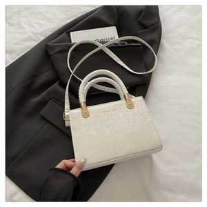 Detail of stone pattern texture on white crossbody bag with gold fashion lettering