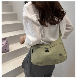 Dettaglio della borsa a tracolla in nylon verde chiaro impermeabile con zip metallica
