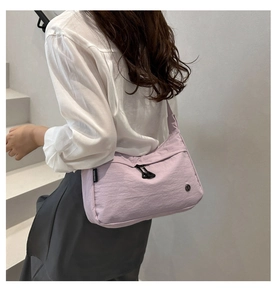 Dettaglio della borsa a tracolla in nylon lavanda impermeabile con trama e etichetta laterale
