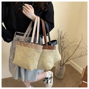 Detail of three chic woven straw tote bags with leather straps and metallic accents