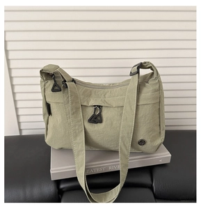 Dettaglio della borsa a tracolla in nylon verde chiaro con trama del tessuto e zip frontale