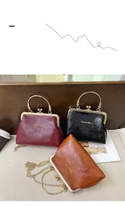 Dettaglio di borse a scatto vintage in pelle rossa, nera e marrone con manico in metallo
