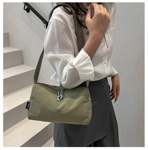 Detail of green canvas crossbody bag showing durable texture and branded woven label
