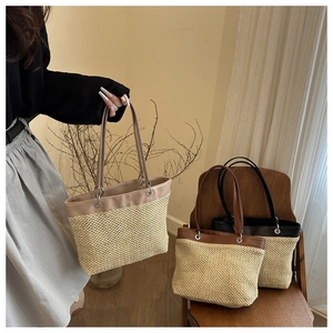 Detail view of woven straw tote bags in beige, brown, and black with leather straps